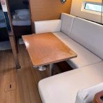 Jeanneau Sun Odyssey 440 yacht saloon with lounge area, dining table and natural light