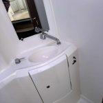 Modern bathroom aboard the Lagoon 380 catamaran with shower, washbasin and marine toilet